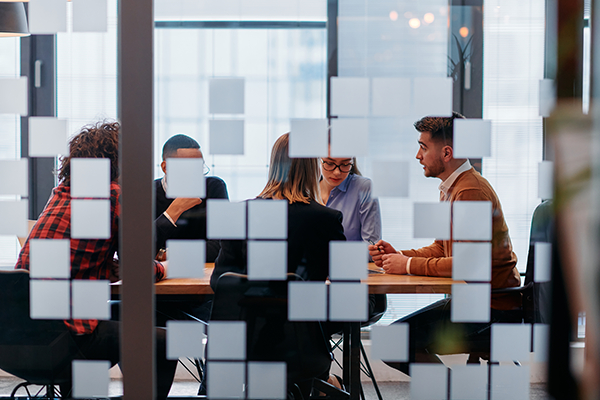 looking through window with design at people in a meeting
